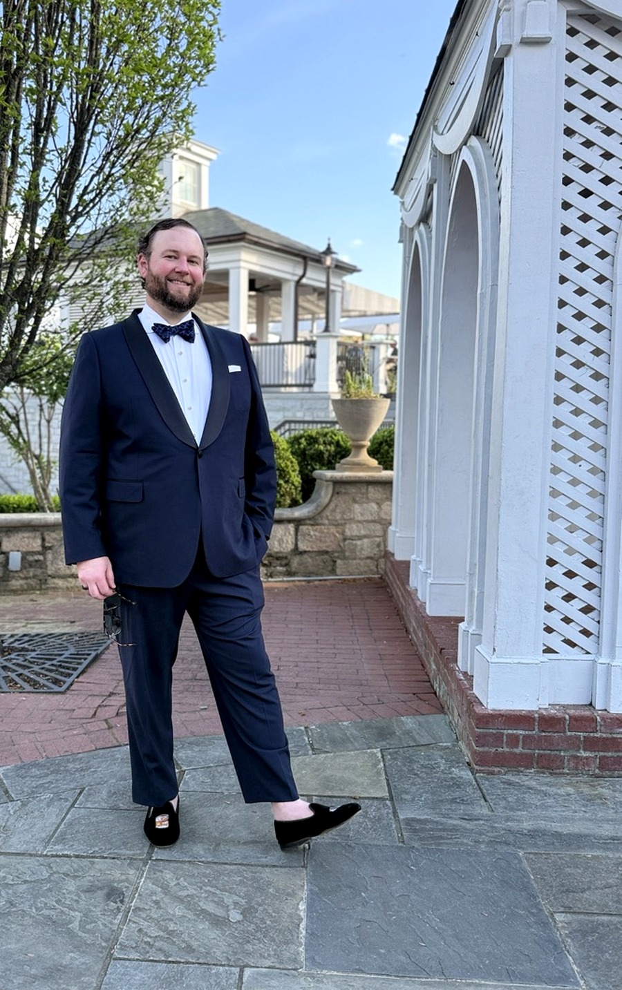 ST Bespoke founder in custom navy shawl-lapel tuxedo on a stone terrace